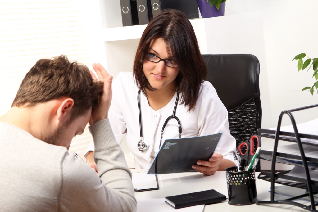 Young woman doctor talking with patient